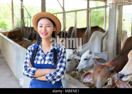 Asie happy farmer posing dans une étable Banque D'Images