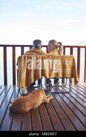 Couple confortable et chien sur balcon Banque D'Images