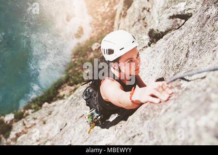 Concentré, déterminé female rock climber scaling rock Banque D'Images