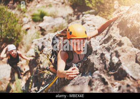 Concentré, déterminé female rock climber hanging from rock Banque D'Images