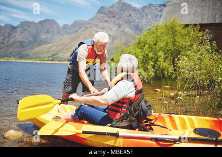 Couple actif du kayak sur le lac d'été ensoleillé Banque D'Images