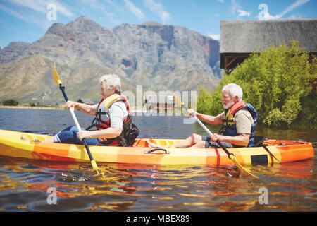 Couple actif du kayak sur le lac d'été ensoleillé Banque D'Images