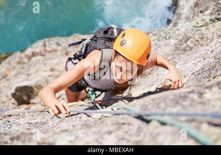 Concentré, déterminé female rock climber scaling rock Banque D'Images