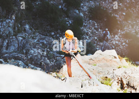 Female rock climber rappelling rock Banque D'Images