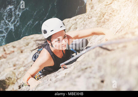 Concentré, déterminé female rock climber scaling rock Banque D'Images