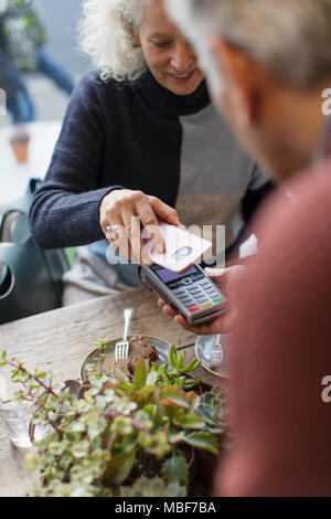 Femme avec l'aide de smart phone paiement sans contact Banque D'Images