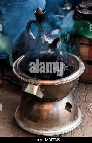 Pot à café en céramique éthiopien traditionnel poêle du charbon sur bouillante au cours de cérémonie du café éthiopienne à Addis-Abeba, Ethiopie Banque D'Images