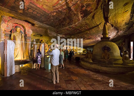 Vue horizontale de touristes marcher autour de la grotte des grands rois dans le Temple Dambulla au Sri Lanka. Banque D'Images