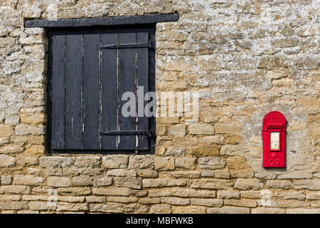 Vieux Mur de pierre avec une fenêtre en bois articulée et une vieille boîte aux lettres rouge ; inset Ravenstone, España Banque D'Images