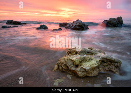 Lever du soleil aux couleurs orange et rouge ciel , rocks on foreground Banque D'Images