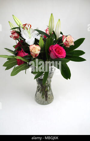 Bouquet de fleurs roses et de lys en vase en cristal de verre Banque D'Images