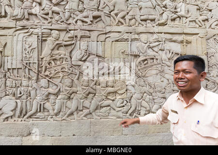 Tour guide, parlant de l'sculptures, temple Bayon, Angkor Thom, site du patrimoine mondial de l'Asie, Cambodge Banque D'Images