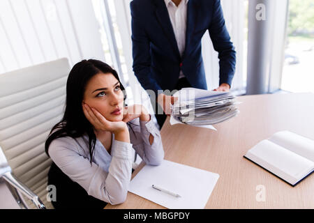 Businesswoman having maux de tête d'avoir trop de travail à faire à partir de son patron Banque D'Images