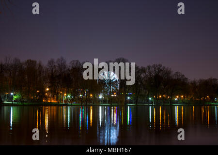 Le fun park volant vu de l'autre côté du lac dans le parc Herastrau, à Bucarest, Roumanie. Banque D'Images