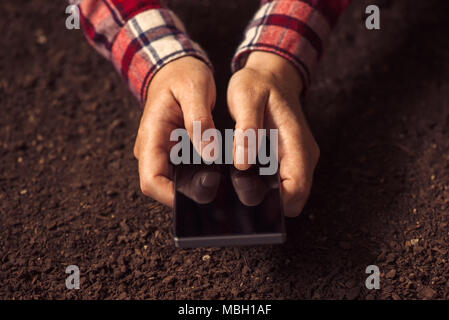 À l'aide d'agriculteurs smartphone, femmes à l'aide de téléphone sur la masse du sol Banque D'Images