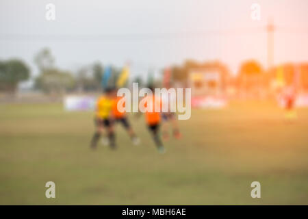 Profondeur de champ à coup de jeunes garçons jouant un mini match de football sur gazon vert Banque D'Images