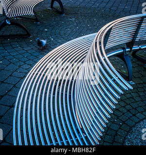 Des tables en acier courbé dans un centre-ville. Banque D'Images