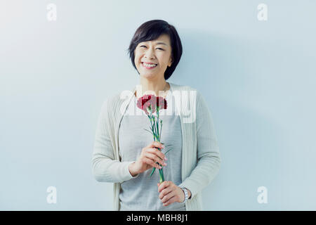 Japanese woman holding red roses Banque D'Images