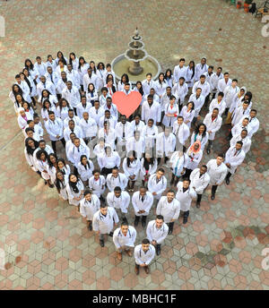 Kiev, Ukraine - 22 Avril 2018 : les étudiants en médecine à terre, faire le grand cœur de charité. Les personnes de nationalités différentes. Physycians vêtus de blanc uniforme médical. L'action de bienfaisance. Banque D'Images