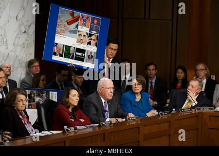 Washington, USA. 10 avr, 2018. Une aide pour le sénateur Patrick Leahy, Démocrates de New York, est titulaire d'un panneau avec de faux news articles utilisés dans l'élection présidentielle américaine de 2016 comme le sénateur demande Facebook PDG Mark Zuckerberg une question alors qu'il témoigne devant le Sénat des États-Unis sur la colline du Capitole à Washington, DC Le 10 avril 2018. Crédit : l'accès Photo/Alamy Live News Banque D'Images