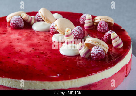 Décoration avec des framboises, des chocolats et des biscuits sur un gâteau Banque D'Images