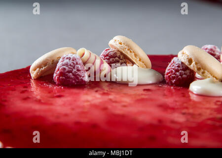 Décoration avec des framboises, des chocolats et des biscuits sur un gâteau Banque D'Images