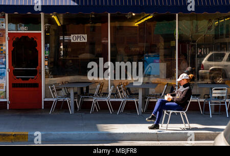 Femme appréciant le déjeuner au soleil à l'extérieur de Sweetie's Deli ; District historique national ; Salida, Colorado, USA Banque D'Images