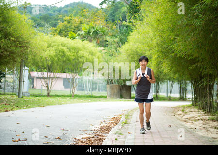 Vue avant du senior woman jogging through park Banque D'Images