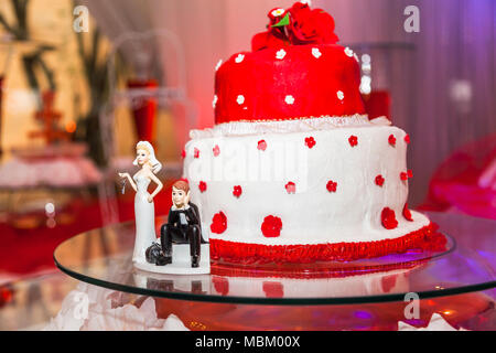 Univers miniatures sur fond de gâteau de mariage rouge et blanc Banque D'Images