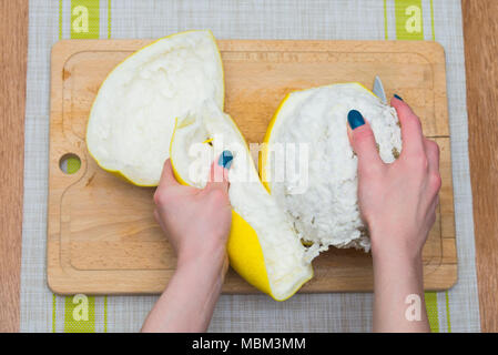 Girl cleaning ses mains avec agrumes pomelo, sur une planche en bois Banque D'Images