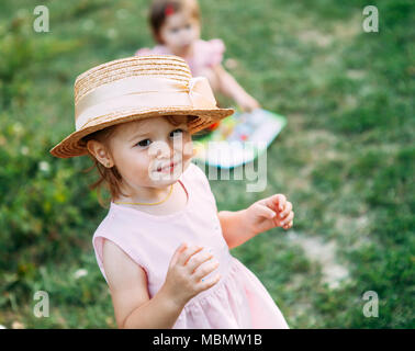 Les petites filles jouent dans la nature cute baby girl portrait.petite fille dans un chapeau de paille sourit un espace réservé au texte Banque D'Images