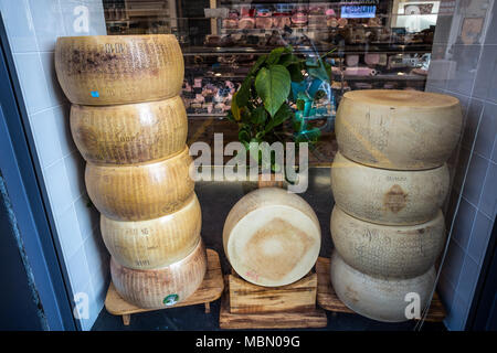 Gênes, Italie, le 5 avril 2018 - formes empilées Parmigiano Reggiano, le plus célèbre fromage italien en vente dans un magasin. Banque D'Images