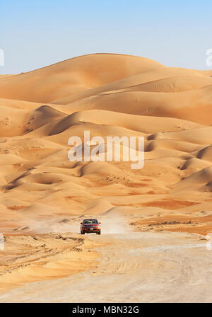 Un véhicule roulant à travers les dunes de sable dans le Rub Al Khali ou quart vide. Les stocks de l'Oman, l'Arabie saoudite, les Émirats arabes unis et le Yémen, c'est la plus grande du sable Banque D'Images