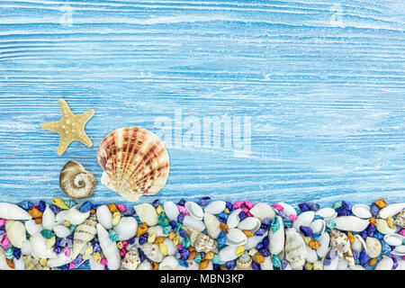 Les étoiles de mer et de décoration marine coquilles peintes de taille différente sur les planches de bois bleu Banque D'Images