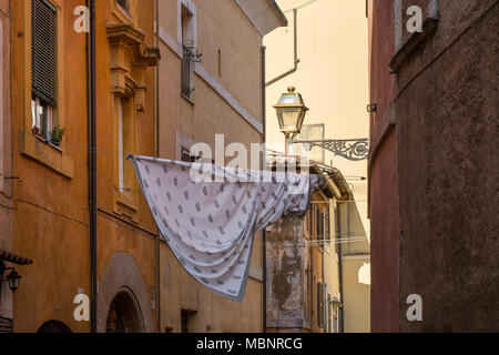 Une feuille accrochée à un lave-ligne entre les bâtiments dans le Trastevere de Rome, Italie. Séchage de blanchisserie est un établissement emblématique vue au-dessus des rues italiennes. Banque D'Images