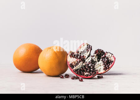 Oranges mûres délicieux et grenade sur surface en marbre Banque D'Images