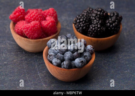 Fruits des bois, framboises, bleuets et mûres, sur une planche à découper ardoise Banque D'Images