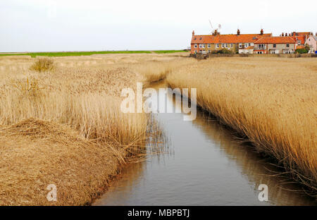 Une vue de la rivière Glaven circulant dans les lits de roseaux vers le moulin sur la côte nord du comté de Norfolk à Claj-next-the-Sea, Norfolk, Angleterre, Royaume-Uni, Europe. Banque D'Images