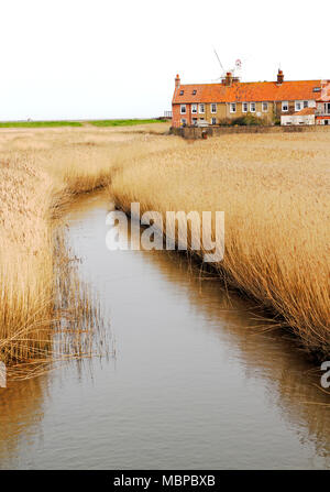 Une vue de la rivière Glaven circulant dans les lits de roseaux vers le moulin sur la côte nord du comté de Norfolk à Claj-next-the-Sea, Norfolk, Angleterre, Royaume-Uni, Europe. Banque D'Images