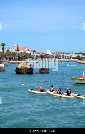 Les touristes en canot sur la rivière Bansafrim avec vue sur la ville, Lagos, Algarve, Portugal, Europe. Banque D'Images