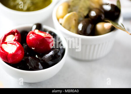 Olives et tomates à la feta en boules blanches sur fond gris. Banque D'Images