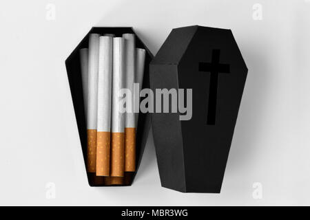 Des cigarettes dans un cercueil noir sur fond blanc - Arrêter de fumer concept Banque D'Images