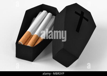 Des cigarettes dans un cercueil noir sur fond blanc - Arrêter de fumer concept Banque D'Images