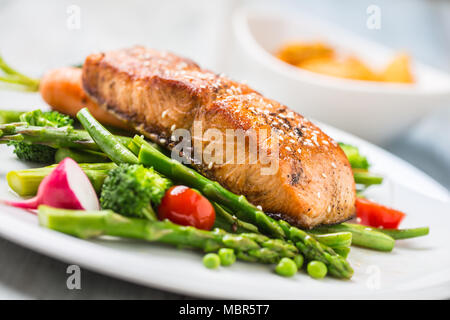 Pavé de saumon grillé avec asparagos brocoli radis Tomates haricots verts et pois. La farine de poisson avec légumes frais. Banque D'Images