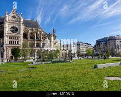 Les gens qui marchent en face de l'église Saint Eustache, situé de l'autre côté park Nelson Mandela, à côté des Halles dans le 1er arrondissement. Paris, France. Banque D'Images