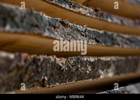 En bois plié brun et gris bandes dans une scierie. D' aulne empilés comme texture. Banque D'Images