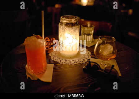 Après le travail des boissons comprenant un cocktail rose et du whisky dans un verre sur une table Banque D'Images