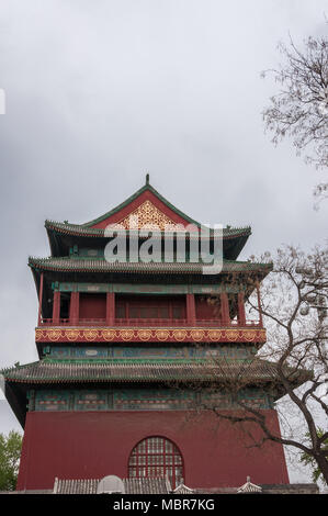 Beijing, Chine - le 26 avril 2010 : côté court de structure supérieure de la Tour du Tambour montre de bordeaux, des couleurs vert et or sous ciel gris. Certains arbre en photo. Banque D'Images