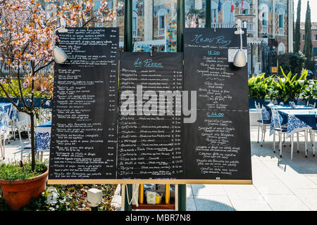 Menu et prix en anglais et italien sur un panneau d'affichage dans les rues de Lido Banque D'Images