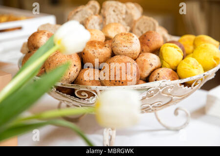 Libre d'un buffet de mariage, peu de pain de blé entier dans un vintage metal montage avec des problèmes de mise au point sur la droite tulipes blanches Banque D'Images